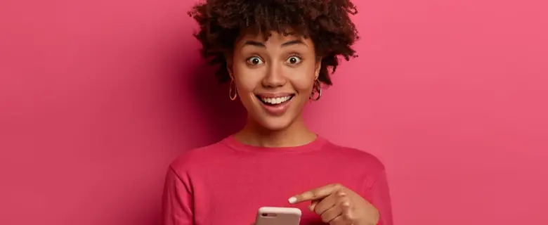 Woman smiling and pointing at her phone